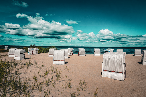 Two beach chairs in front of a peaceful beach scene.