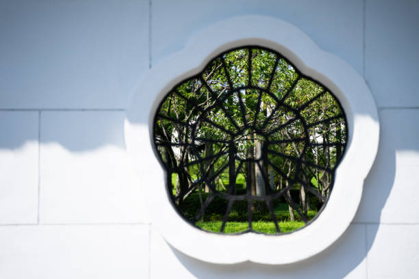istock Branches and leaves seen through flower-shaped windows 1500283841
