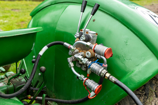 The hydraulic system on a tractor. Metal and rubber pipes, control arms