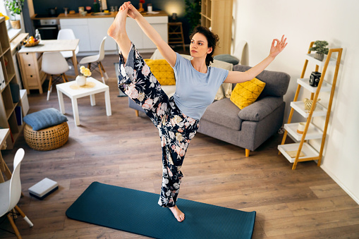 Young woman practicing yoga at home.