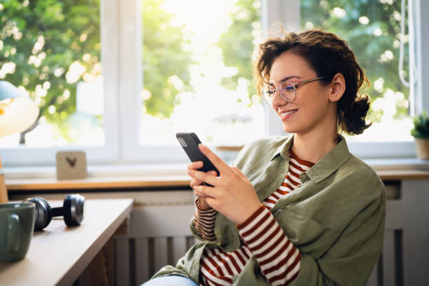 istock Beautiful young woman texting messages on her phone 1500286804