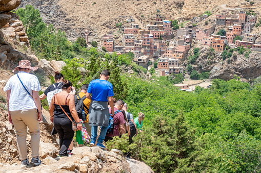 People in a tour group hiking towards a village in Ourika Valley in Atlas Mountains, Morocco