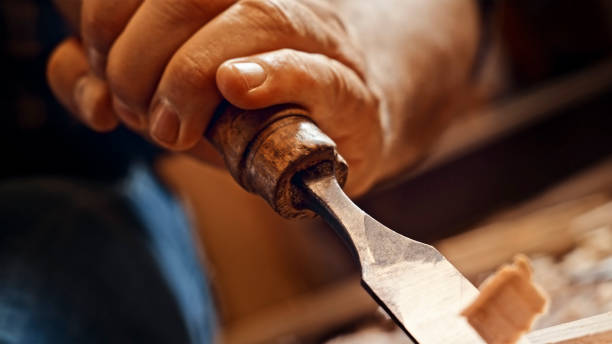 istock Carpenter shapes wood with chisel 1500290808