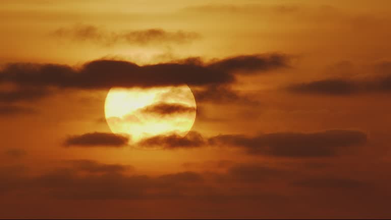 Beautiful evening sunset with big Sun and dark clouds in the Atlantic Ocean at Portugal coast.