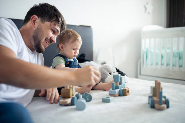 istock Father and son playing with wooden blocks making a train. 1500293985