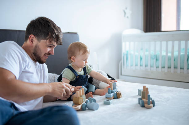 istock Father and son playing with wooden blocks making a train. 1500293993