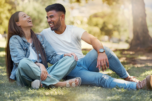 Couple are happy outdoor, laughing and relax together, love and care with trust in relationship and commitment. Happiness, support and freedom with man and woman in park with romance and bonding