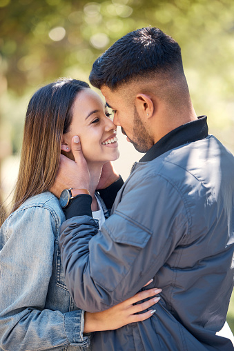 Smile, outdoor and couple with love, care and happiness together in summer. Young man and woman happy face at nature park for affection or kiss on a romantic date, holiday or vacation to relax