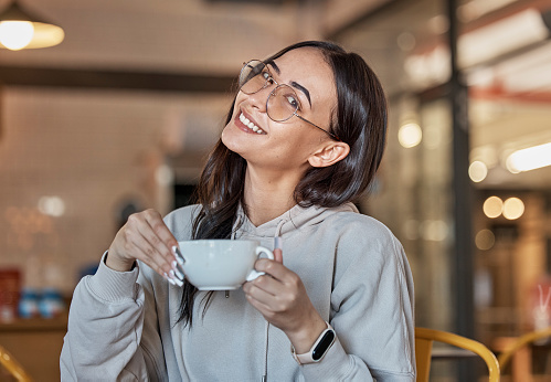 Coffee shop, relax and portrait of woman with smile in restaurant for hot beverage, cappuccino and latte. Happy, cafe and face of girl sitting by table for calm, relaxation and happiness on weekend