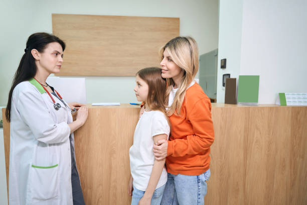 istock Front desk assistant greeting clients and asking to wait for pediatrician call 1500300036