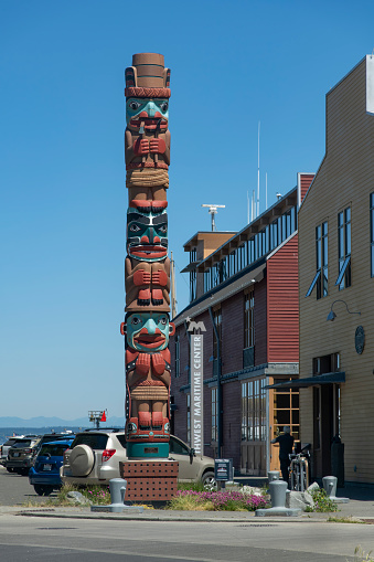 Port Townsend, WA, USA-July 2022; Vertical view of a totem pole in downtown Port Townsend Historic District which is a homage to finely crafted wooden boats and for the artisans who build them