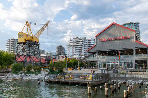 Vancouver, BC, Canada-July 2022; View of The Shipyards event space and renovated crane from the dock of former Burrard Dry Dock Company (originally Wallace Shipyards) in North Vancouver