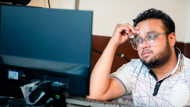 istock Stressed young businessman working on computer in the office. 1500305000