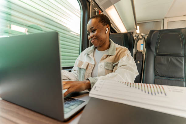 istock A beautiful young woman is reviewing financial documents and working on a laptop while traveling with train to work. 1500306950