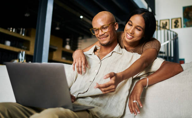 istock A young man is being embraced from behind by a young woman while looking at his laptop computer. Stock photo 1500308164