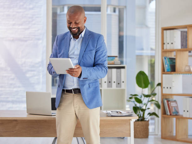 istock Happy, tablet and research with black man in office for digital, communication and email. Internet, technology and corporate with male employee in agency for planning, online and business networking 1500308981
