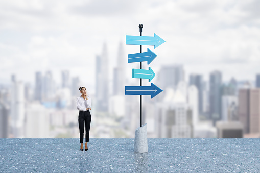 Choice, professional decision and changes concept with pensive woman on the roof near signpost with blue arrows different direction on city skyline background