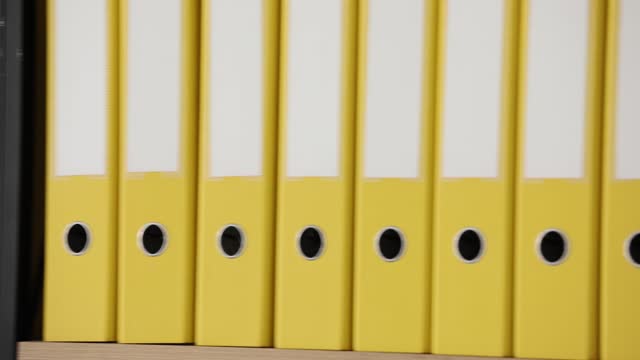Yellow folders with folders and documents in long rows on shelves