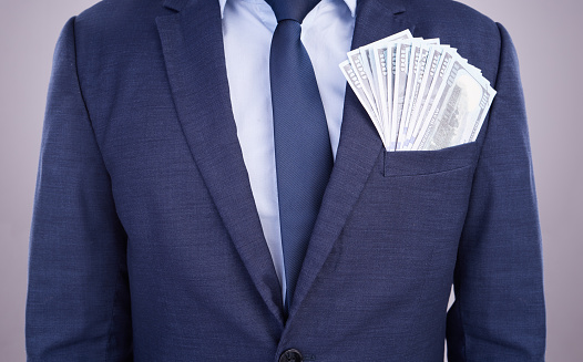 Wealth, bonus and businessman with money in a suit isolated on a white studio background. Rich, finance and a corporate employee with cash from an investment, payment or salary in accounting