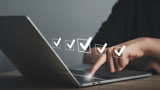 Performance checklist template for employees or check box questionnaire survey.  businessman using laptop doing online checklist, filling out digital form checklist. Business management goal strategy.