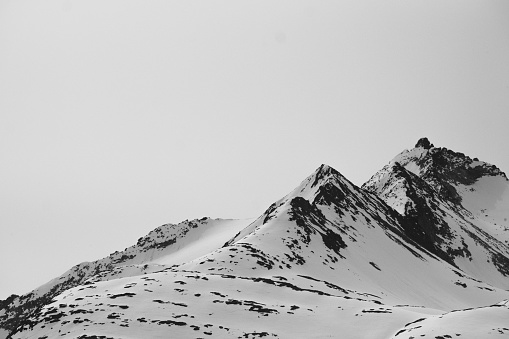 Snow and mountains with featureless sky in monochrome