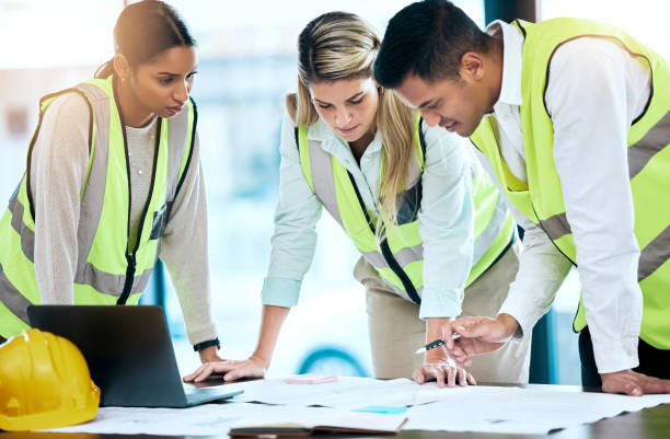 istock Architect, team and meeting in blueprint planning for construction, architecture or project collaboration. Group of contractors discussing floor plan or teamwork strategy for industrial architecture 1500332505
