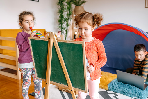 Two little girls learning how to draw