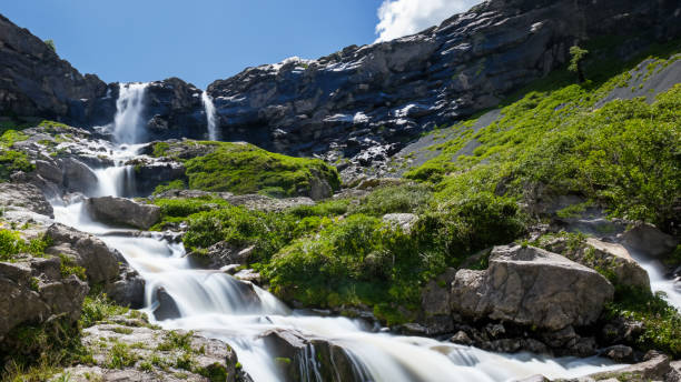 istock Sunny day and  waterfall flowing through the mountains 1500338332