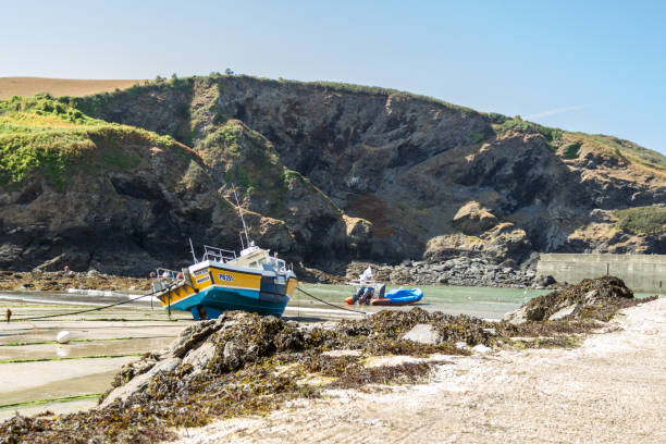 Small boats on a steep slip way with an old winch station in the background.