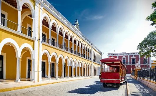 Red tourist bus at the Independence Park (plaza) of the  colorful and picturesque city of Campeche, Mexico