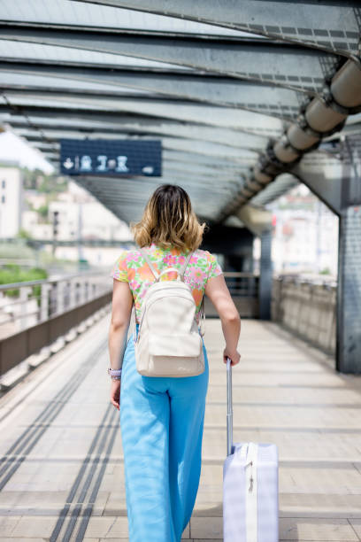 istock Young tourist walking in train station with suitcases 1500340253