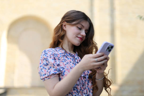 istock Young lady in a dress is typing a message on a smartphone, students communication. 1500343350