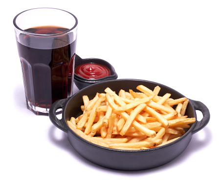 French fries potatoes in black ceramic bowl isolated on white background.