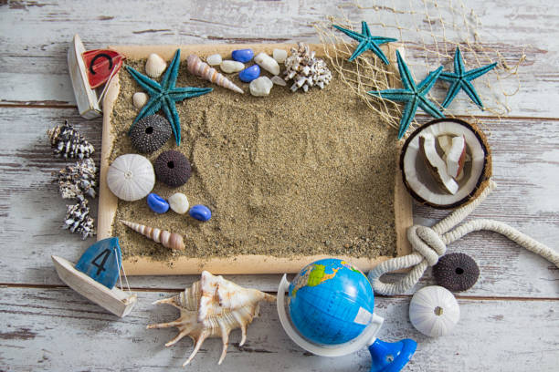 istock Summer holidays background. Starfish, seashells and globe near blackboard on ocean nature beach. Design of summer vacation holiday concept. 1500346741