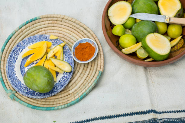Raw mangoes (kairi) cut in a platter with masala for chutney stock photo
