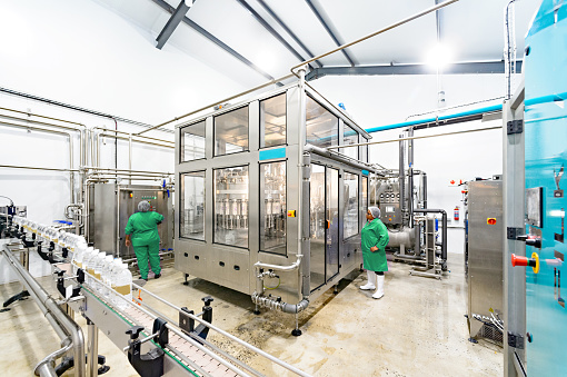 Wide shot Water Bottling Facility with two female quality control inspectors, Cape Town, South Africa