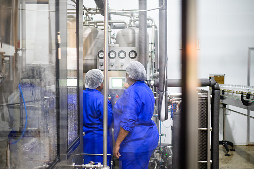 Rear view Two females operating a Water Bottling Facility, Cape Town, South Africa