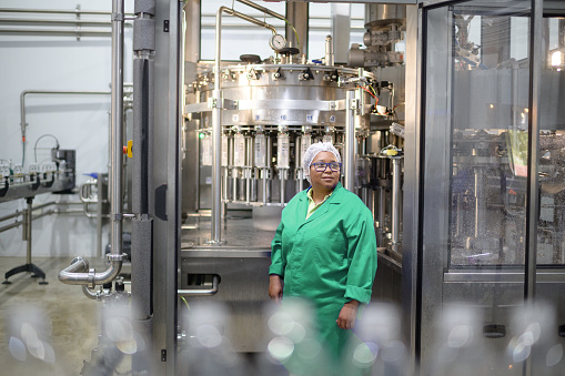 istock Female Operator at Automatic Liquid Filling Machine in Water Bottling Plant 1500349357
