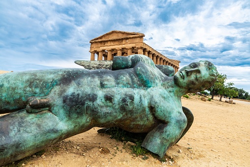 Temple of Concordia and the Icarus bronze statue in the Valle dei Templi or Valley of the Temples in Agrigento, Sicily, Italy
