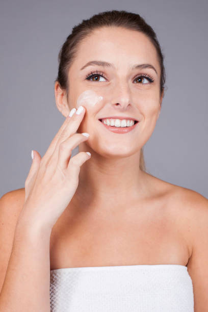 istock Delighted female with radiant skin applying cream 1500356084