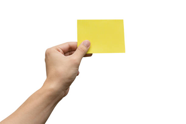 istock Hand holding yellow paper isolated on white 1500356213