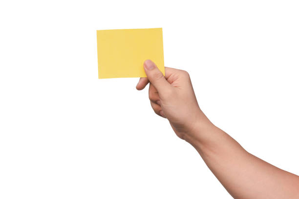 istock Hand holding yellow paper isolated on white 1500356457