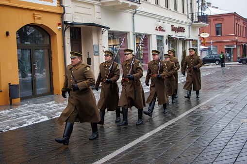 Kaunas, Lithuania – March 11, 2023: A group of uniformed men march in unison down a city street on Lithuania's Day of Restoration of Independence