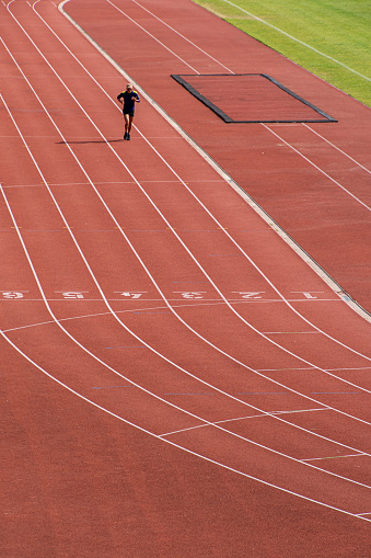 High angle view of men running on running track at stadium, Berlin Wilmersdorf