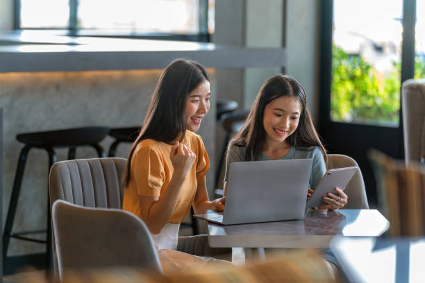 istock Weekend Out-of-Office Collaboration. Asian young female professionals office ladies work from a cafe 1500357708
