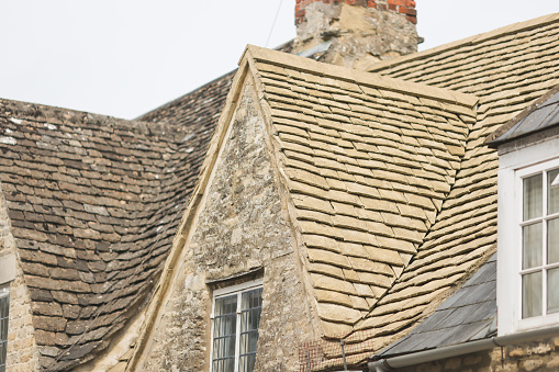 New Cotswold tiled roof on an old stone cottage in Cirencester, Gloucestershire, England