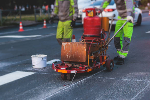 istock Process of making new road surface markings with a line striping machine, workers improve city infrastructure, demarcation marking of pedestrian crossing with hot melted paint on asphalt pavement 1500362595
