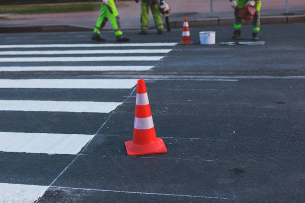 istock Process of making new road surface markings with a line striping machine, workers improve city infrastructure, demarcation marking of pedestrian crossing with hot melted paint on asphalt pavement 1500362599