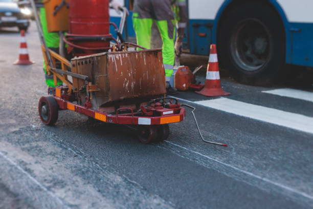 istock Process of making new road surface markings with a line striping machine, workers improve city infrastructure, demarcation marking of pedestrian crossing with hot melted paint on asphalt pavement 1500362624