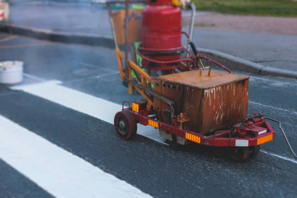 istock Process of making new road surface markings with a line striping machine, workers improve city infrastructure, demarcation marking of pedestrian crossing with hot melted paint on asphalt pavement 1500362631